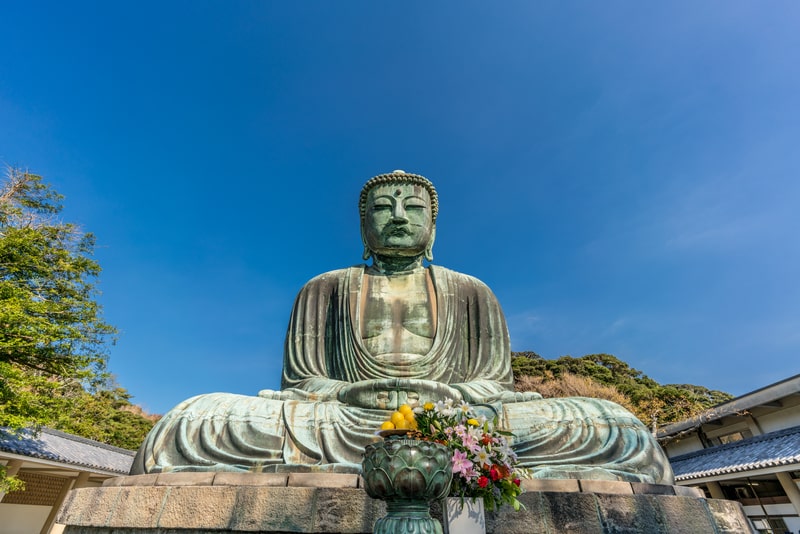 The Great Bronze Amida Buddha statue in Kamakura is a must-see for Budget travel to Japan for students, offering history at no cost.